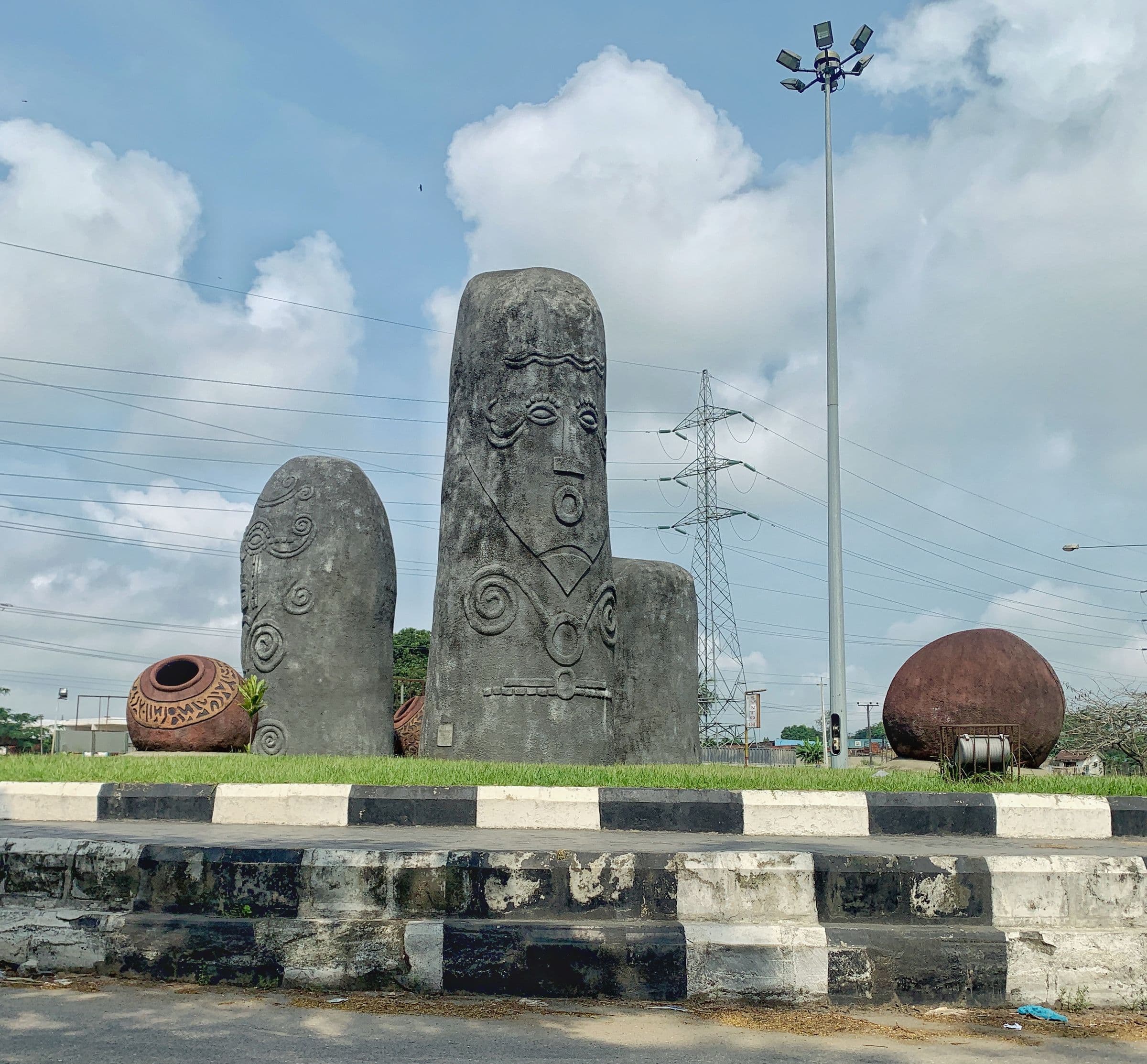 Carved stone monoliths and clay pots at the entrance to Calabar