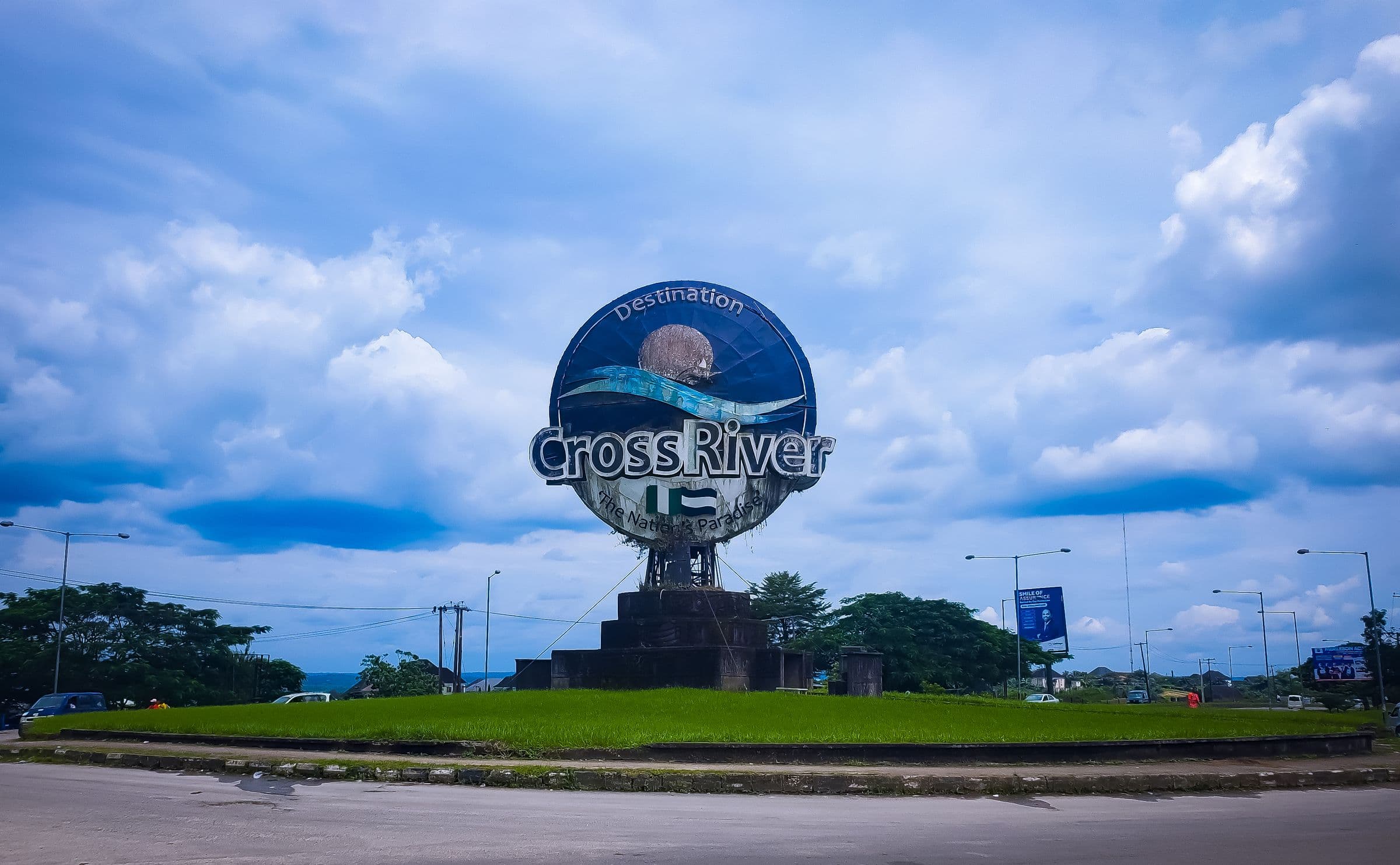 The Destination Cross River monument on a landscaped roundabout under a blue sky