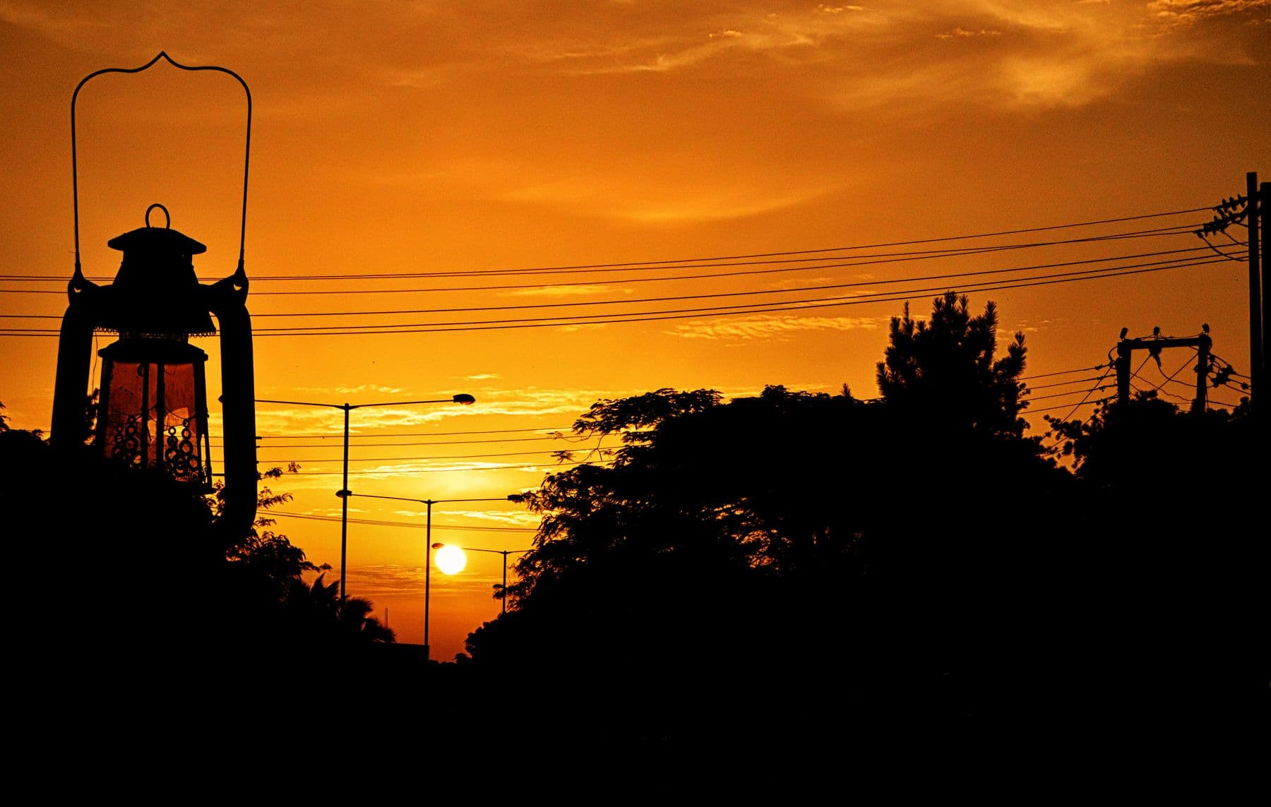 A lantern monument silhouetted against an orange sunset